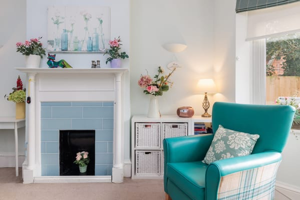 Cozy common area with teal chair and floral decor