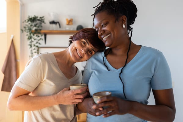 Two women enjoying drinks in a cozy common area