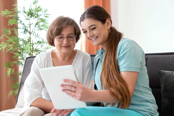 Caregiver and resident engaged with a tablet