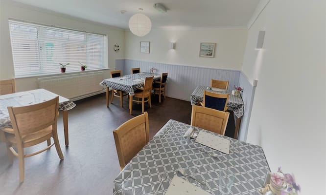 Dining area with tables and chairs in a bright room