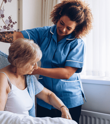 Care staff assisting a resident in a bright room