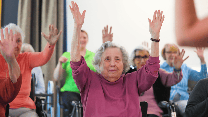 Residents participating in an activity with raised hands