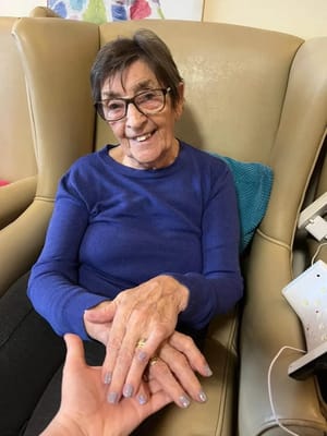 A resident smiling while holding hands with someone