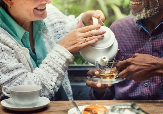 Two residents enjoying tea together indoors