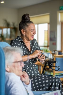 Staff and resident engaged in a cheerful interaction