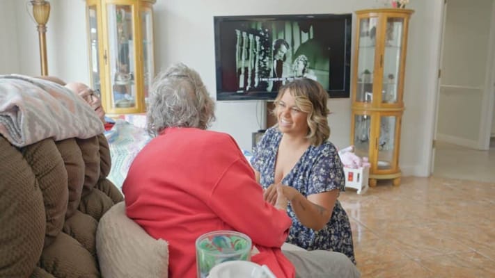 A caregiver interacting with a resident in a cozy interior setting