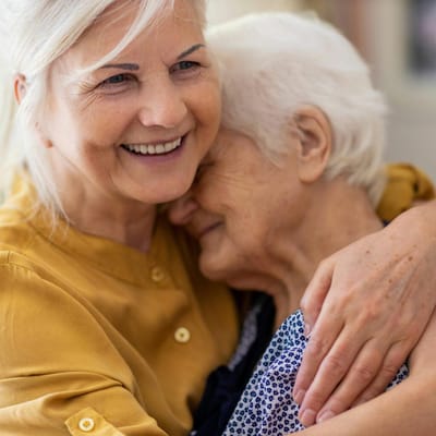 A caregiver embracing a senior resident warmly
