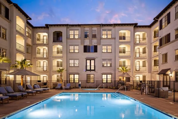 Outdoor pool area with lounge chairs and building facade