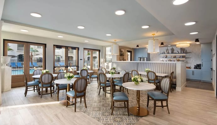 Bright dining room with tables and chairs set for guests