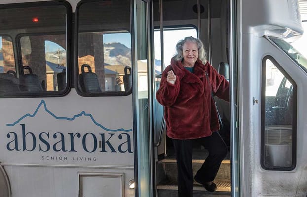 Resident stepping off the facility bus with a smile