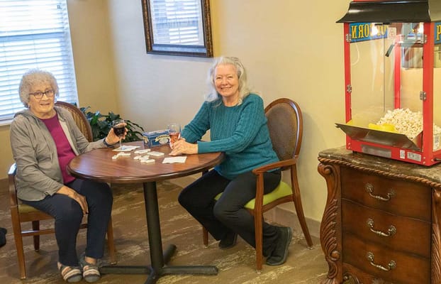 Two residents playing a game in a common area with popcorn machine