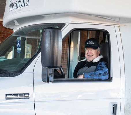 Smiling male staff member in a facility transport vehicle