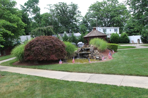 Beautiful landscaped outdoor space with a fountain and flags