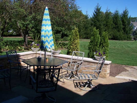 Outdoor seating area with a colorful umbrella and greenery