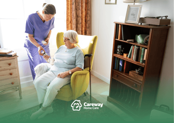 A staff member assisting a resident in a cozy living room