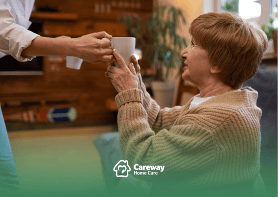 Staff serving tea to a resident in a cozy living space