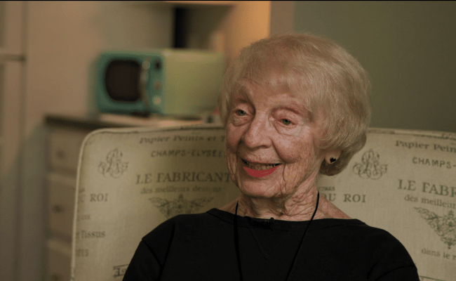 A smiling senior resident in a cozy interior setting