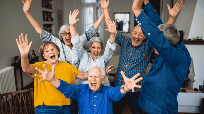 Residents and staff joyfully celebrating together indoors