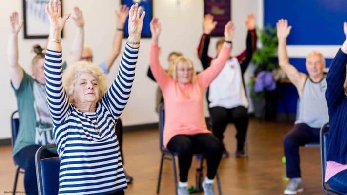 Residents participating in a seated exercise class