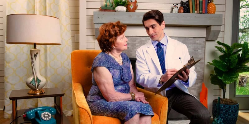 A healthcare professional speaking with a resident in a living room