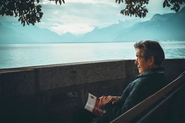 Senior man sitting outside by the water