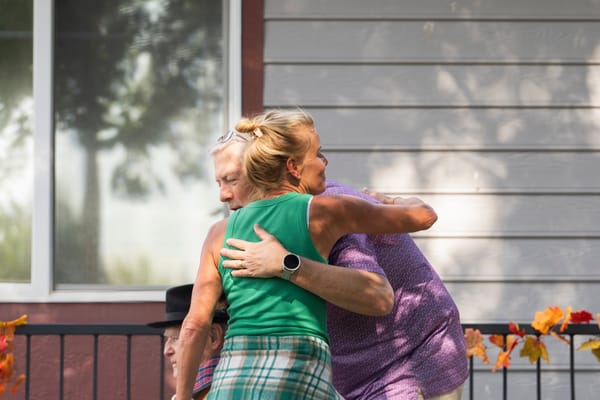 Residents hugging in a garden setting