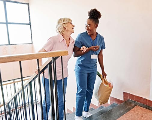 Staff assisting a resident on the stairs