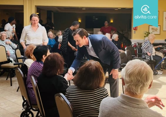 Residents engaging with staff in a lively common area