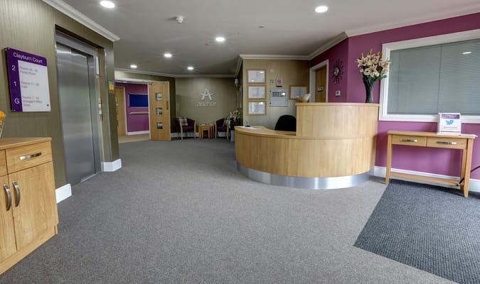 Bright reception area with wooden furniture and elevators