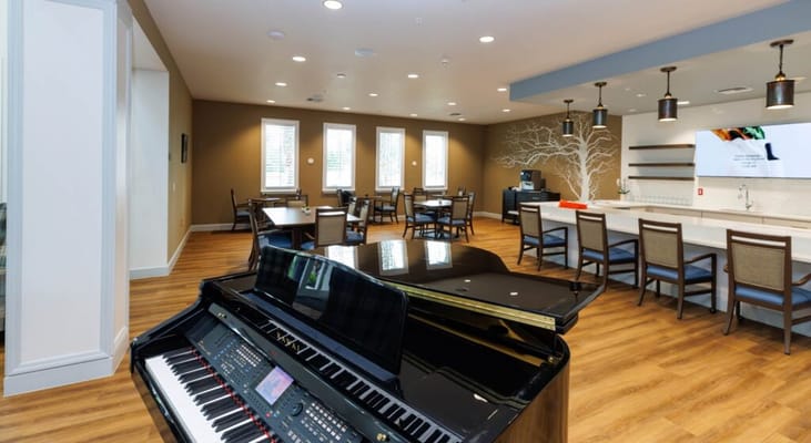 Bright communal area with a piano and tables