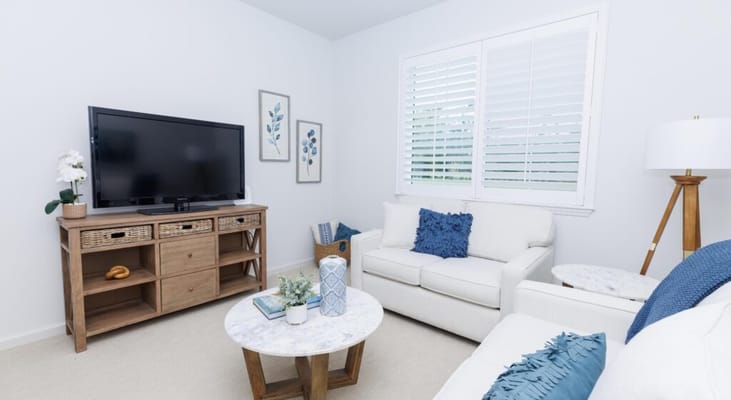 Bright, cozy lounge area with a sofa and TV