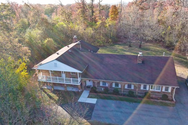 Aerial view of Ray&J Assisted Living surrounded by trees.