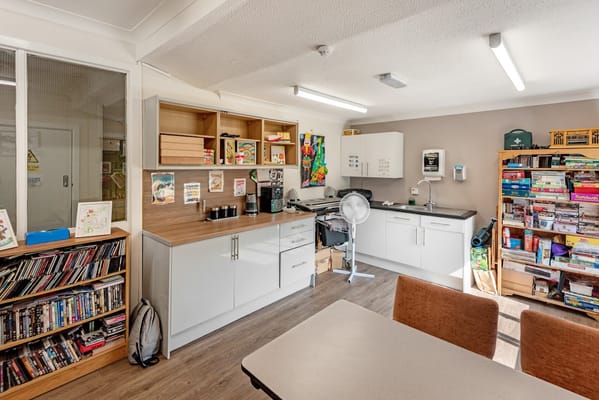 Bright kitchen area with shelves and dining table