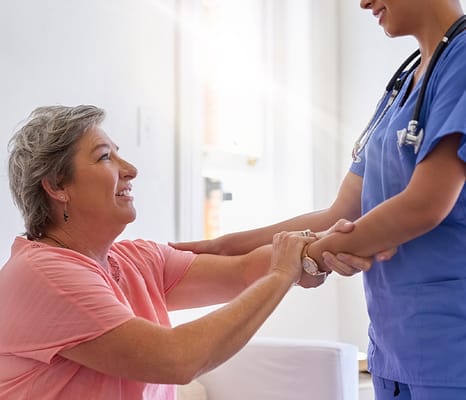 Resident interacting with nursing staff in a bright room