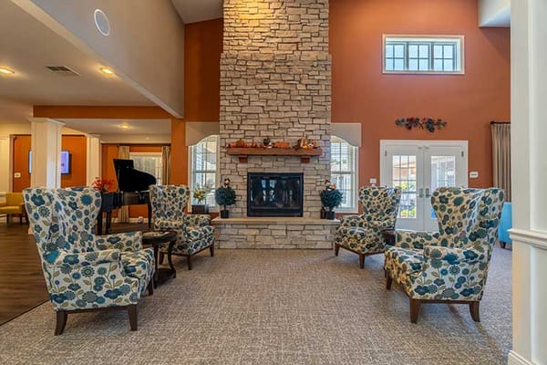 Cozy common area with decorative chairs and stone fireplace