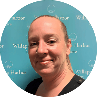 Staff member smiling in front of Willapa Harbor Care backdrop