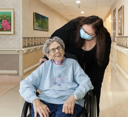 Care staff assisting a resident in a corridor