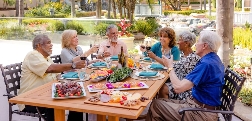 Residents enjoying a meal outside, toasting with drinks
