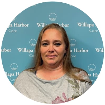 Staff member in front of Willapa Harbor Care backdrop