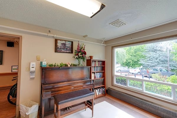 Bright common area with a piano and bookshelves