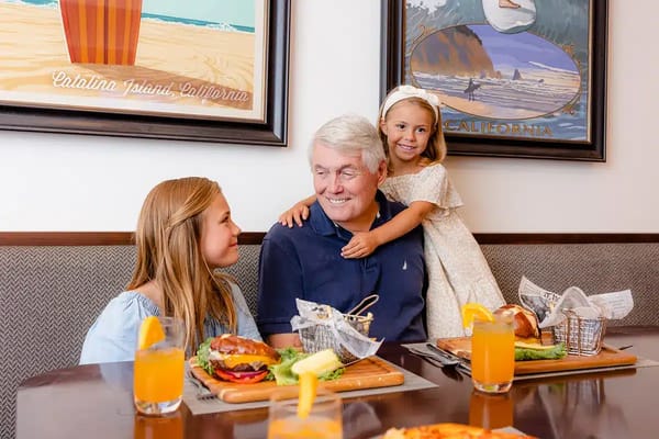 Residents enjoying a meal with family in the dining area
