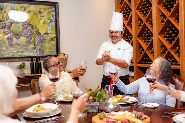 Chef serving dinner at a festive dining table with residents