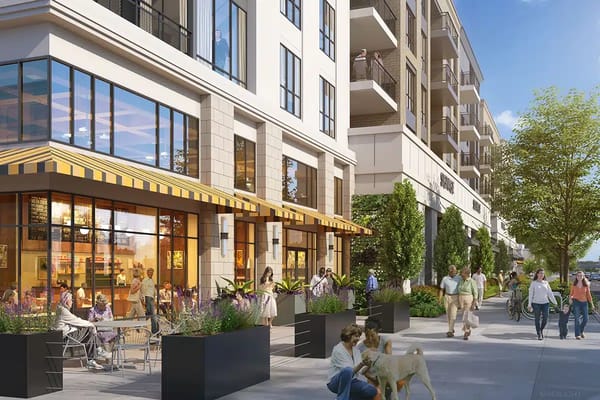 Exterior view of a senior living facility with people walking