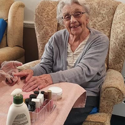 A senior woman enjoying a manicure in a cozy setting