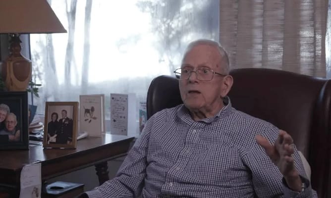An elderly man sitting in a cozy armchair in a room