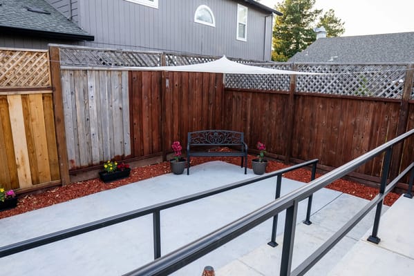 A quiet outdoor space with a bench and flower pots