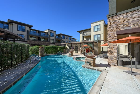 Swimming pool area with lounge chairs and umbrellas