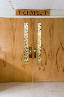Wooden chapel doors with stained glass accents