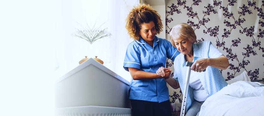 Caregiver assisting an elderly resident in a room