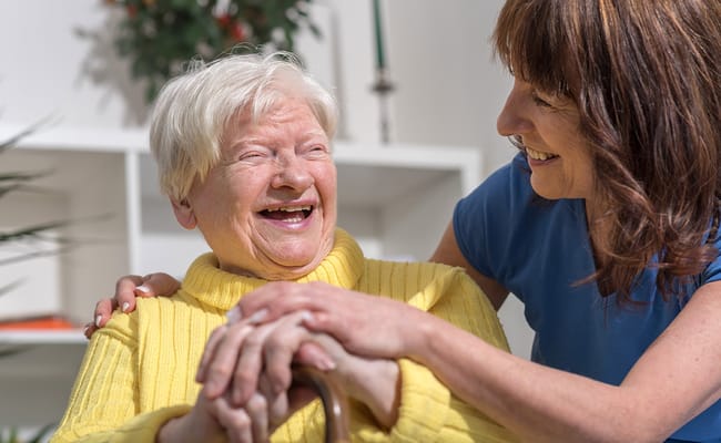 A caregiver and a resident sharing a joyful moment